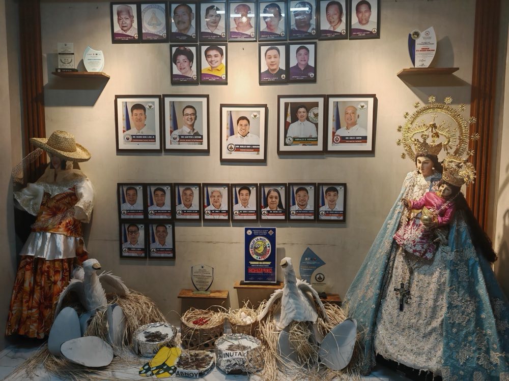 Displey ng pagkilala sa loob ng Barangay Hall — mga larawan ng mga dating Punong Barangay, isang parangal mula sa 3rd Balut sa Puti Festival, at mga simbolo ng kulturang Pateroan sa pato at balut.